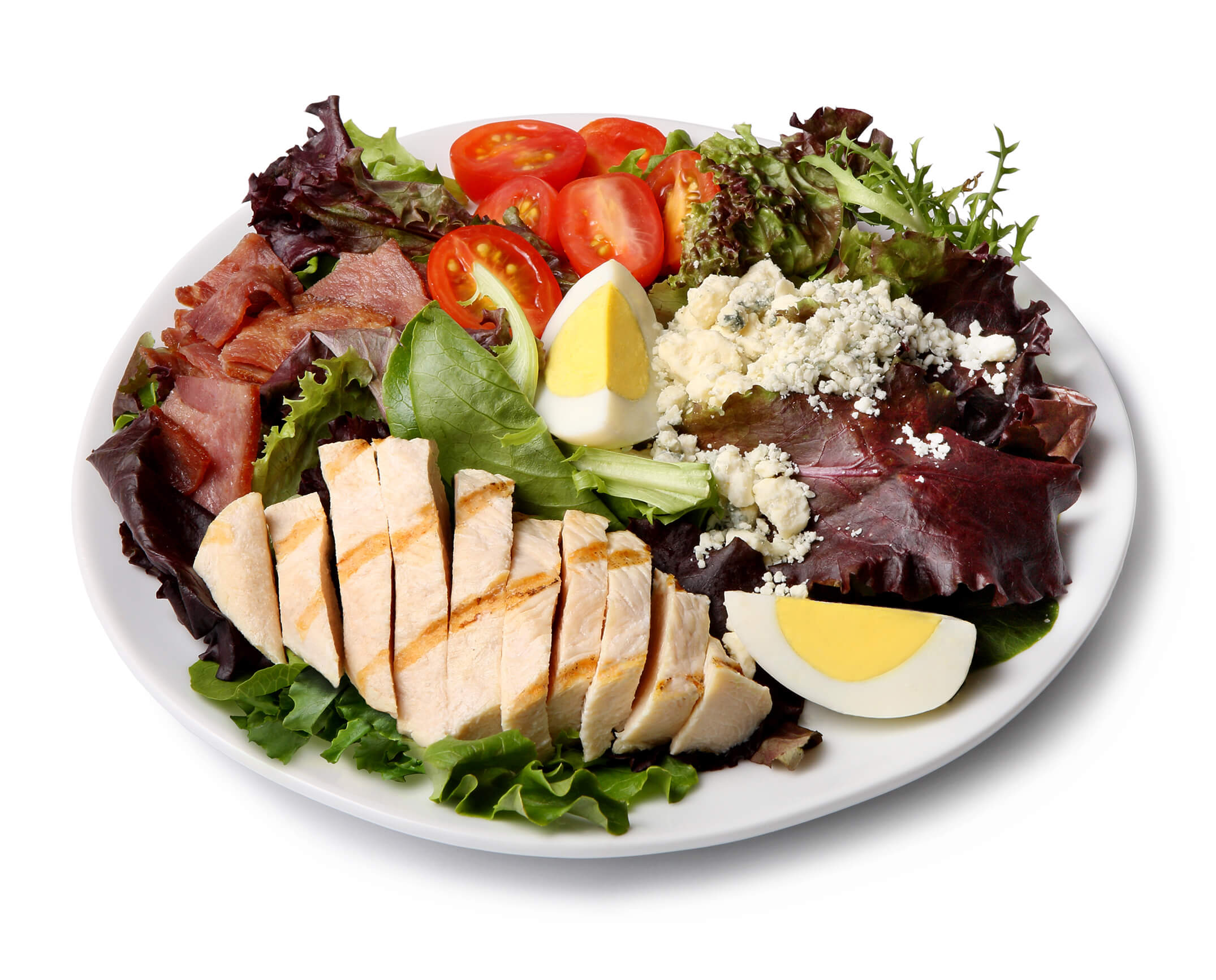 close up of a cobb salad with tomatoes, egg and greens